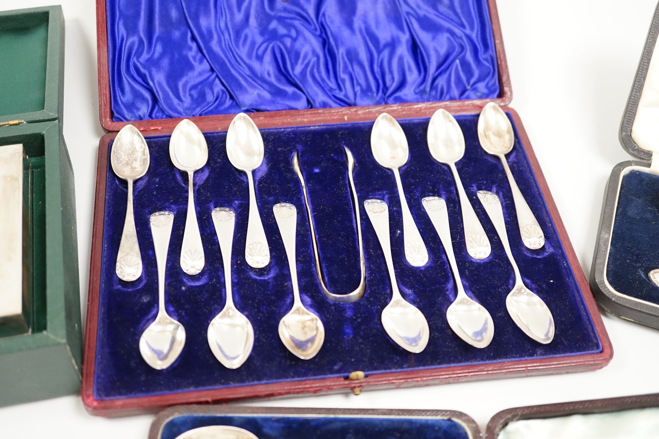 A cased George V silver christening trio, two cased sets of silver teaspoons, including set of twelve with sugar tongs and a cased modern silver mounted presentation cigarette box.